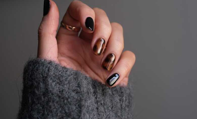 person wearing silver ring with black manicure